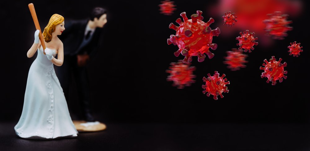 A bride and groom figurine with a baseball bat in front of a virus.