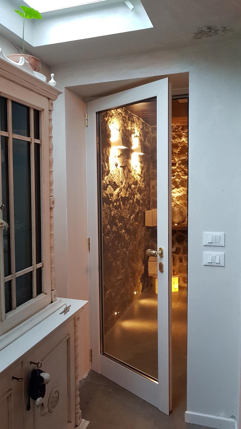 Stretta porta con pannello decorativo illuminato e vetro satinato in un piccolo ingresso interno