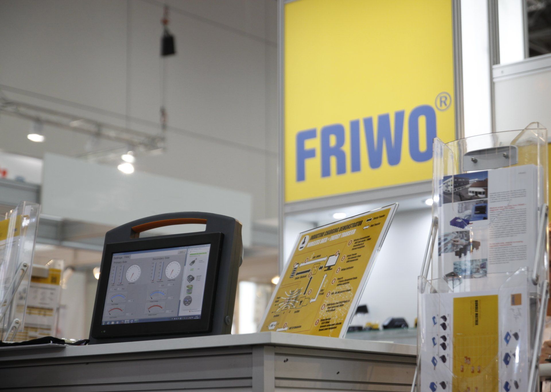 A computer is sitting on a table in front of a friwo sign.