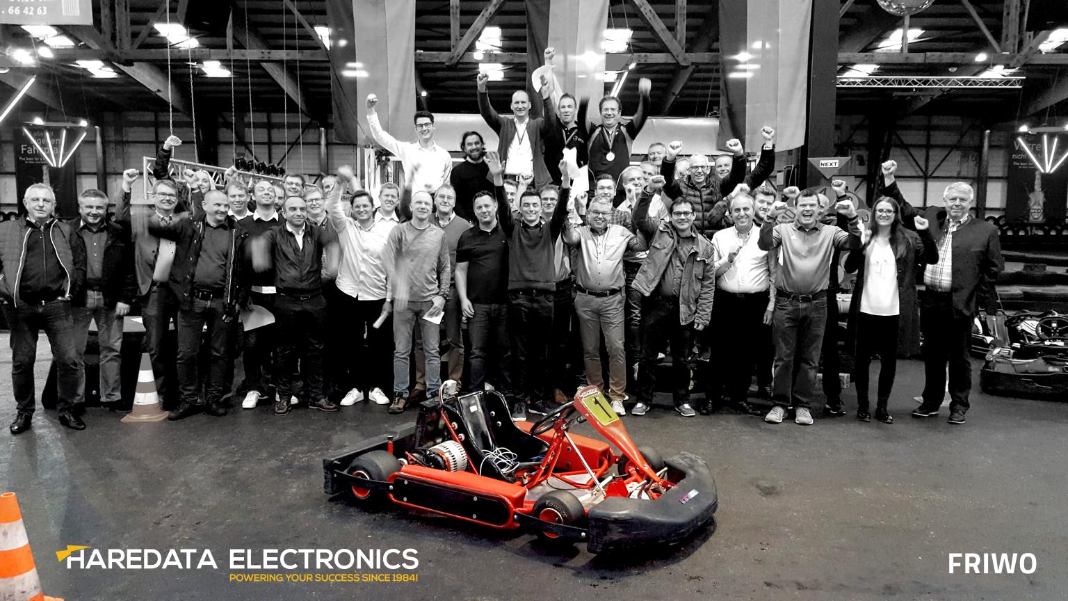 A group of people are posing for a picture in front of a go kart.