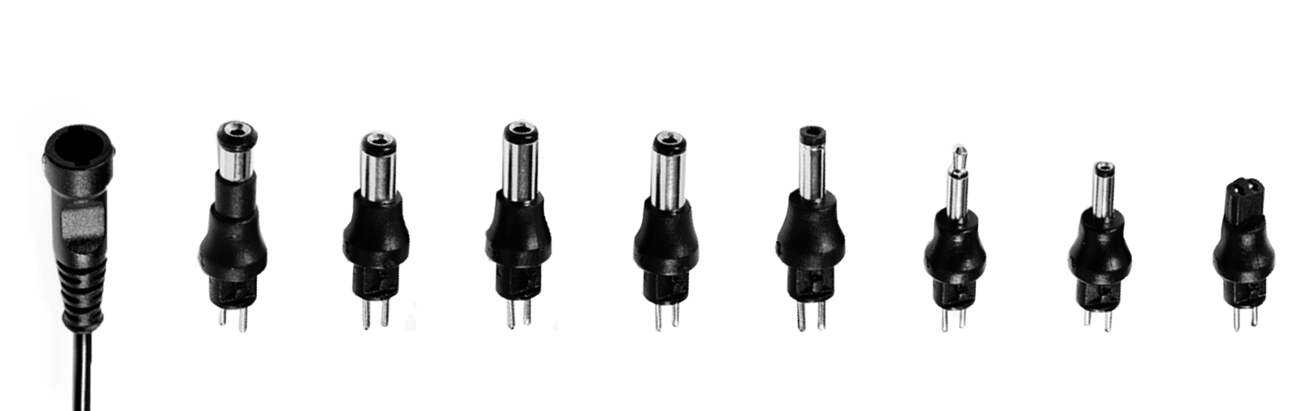 A bunch of different types of DC plugs are lined up in a row on a white background.