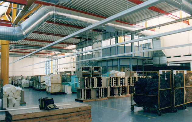 Lagerhalleninnenraum mit Belüftung, Lagercontainern und einem Bürobereich im zweiten Stock.