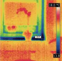 Wärmebild eines Fensterrahmens, das kühlere (blaue) Temperaturen an den Rändern und wärmere (orange) mittlere Bereiche zeigt.