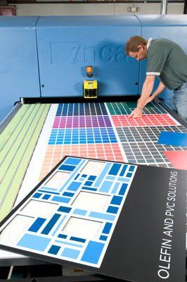 A man is working on a machine that says olefin and pvc solutions