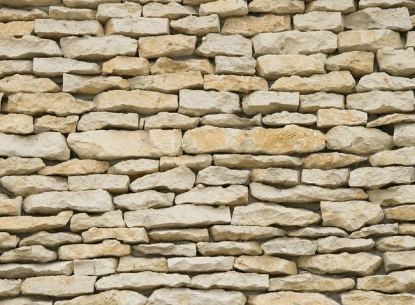 Steinmauer aus hellen, rechteckigen Blöcken.