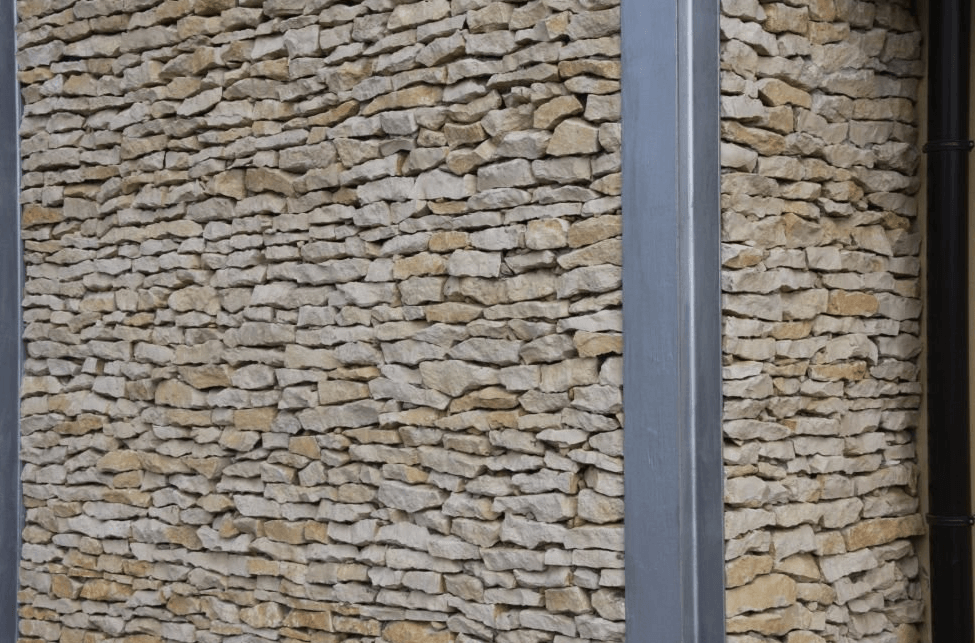 Steinmauer mit grauer Metalleinfassung.
