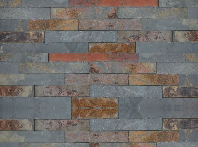 Steinmauer aus grauen, braunen und orangefarbenen rechteckigen Blöcken.