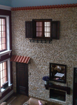 Innenwand mit steinähnlicher Textur, die ein Fenster mit Fensterläden, eine Tür und ein dekoratives Dach aufweist.