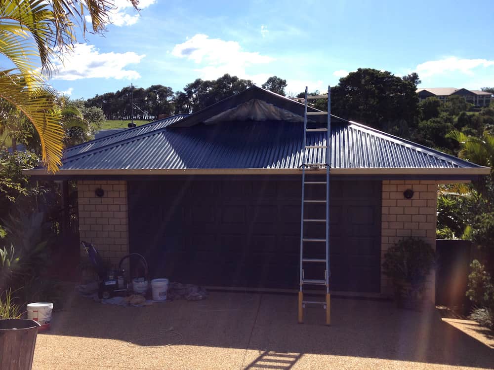A House With a Blue Roof and a Ladder in Front of It — Killiby & Co Roofing Pty Ltd in Tweed, NSW