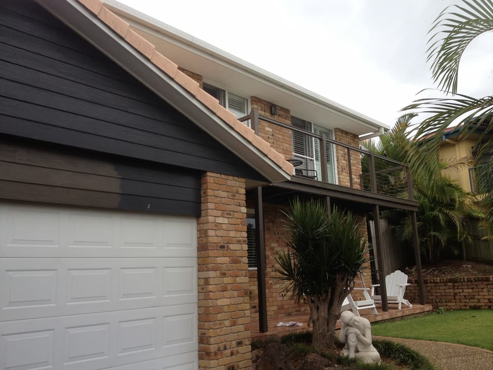 A House With a White Garage Door and a Statue in Front of It — Killiby & Co Roofing Pty Ltd in Tweed, NSW