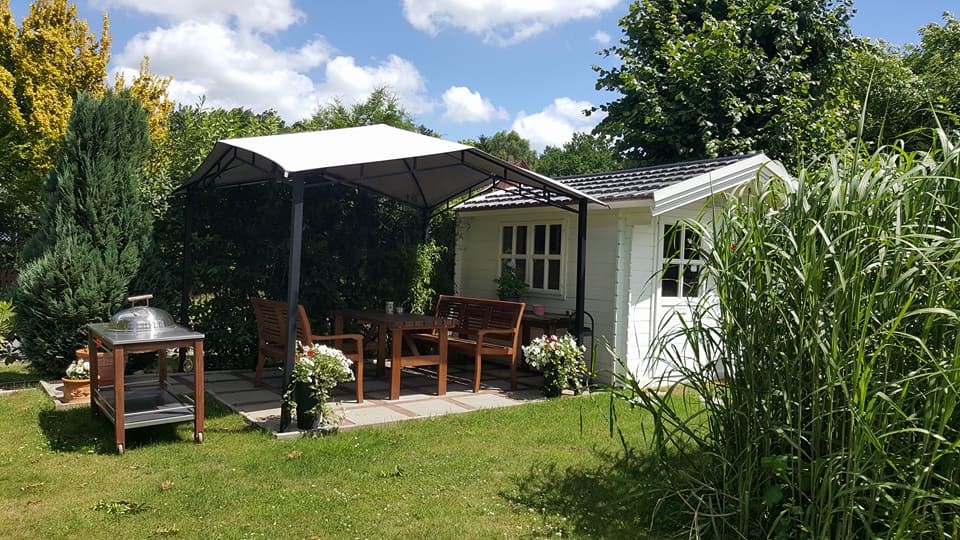 Ein weißes Haus mit einem Pavillon im Hinterhof