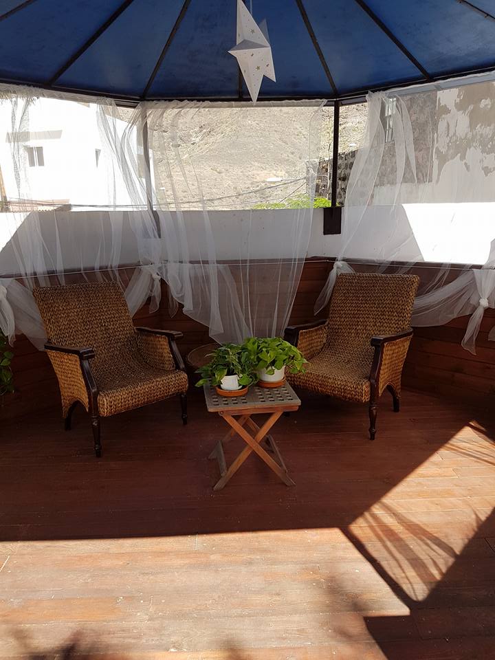 Ein Pavillon mit zwei Stühlen und einem Tisch darunter.