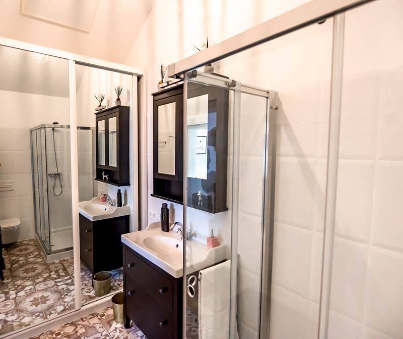 Ein Badezimmer mit zwei Waschbecken und einer Duschkabine