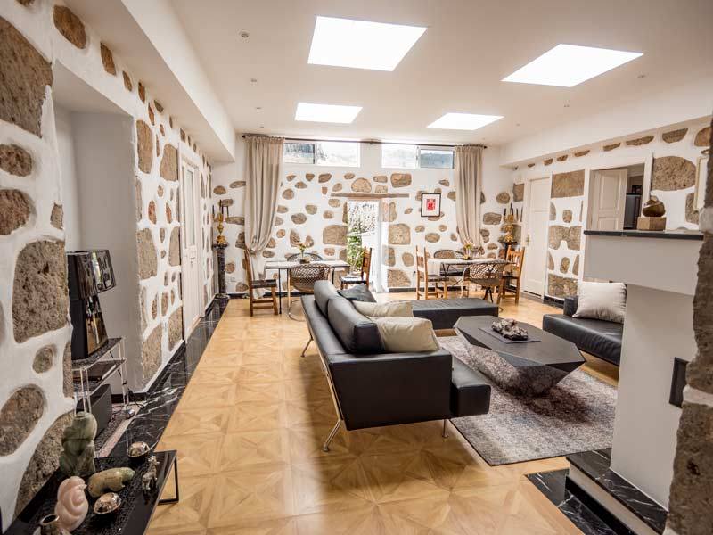 Ein Wohnzimmer mit Couch, Tisch, Stühlen und Kamin.