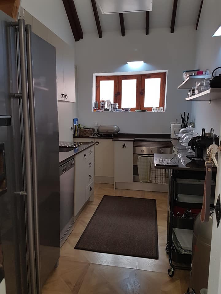 Eine Küche mit Geräten aus Edelstahl und einem Teppich auf dem Boden