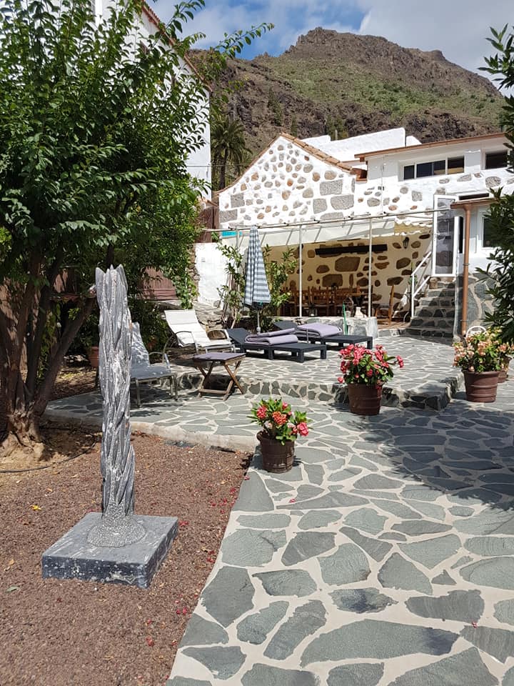 Ein Steinweg, der zu einem Haus mit einem Berg im Hintergrund führt