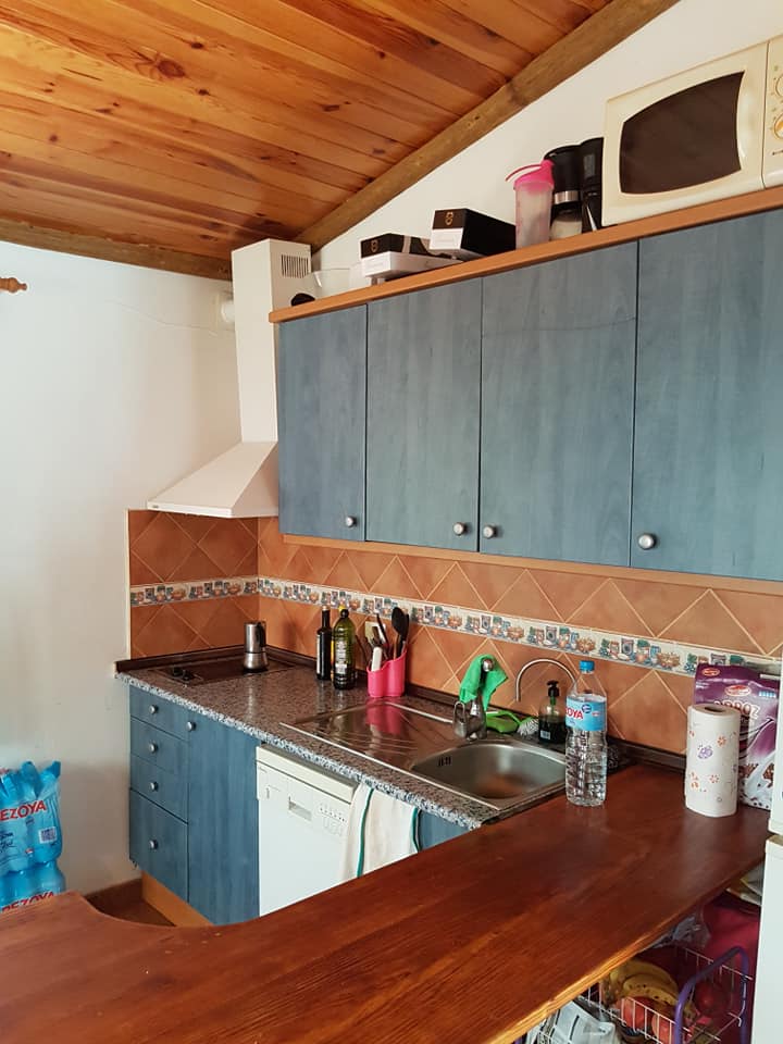 Eine Küche mit blauen Schränken und einer Arbeitsplatte aus Holz