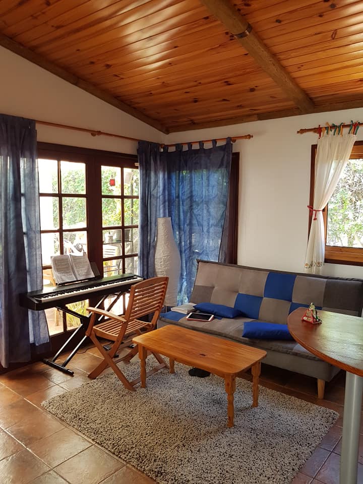 Ein Wohnzimmer mit Couch, Tisch, Stuhl und Klavier.