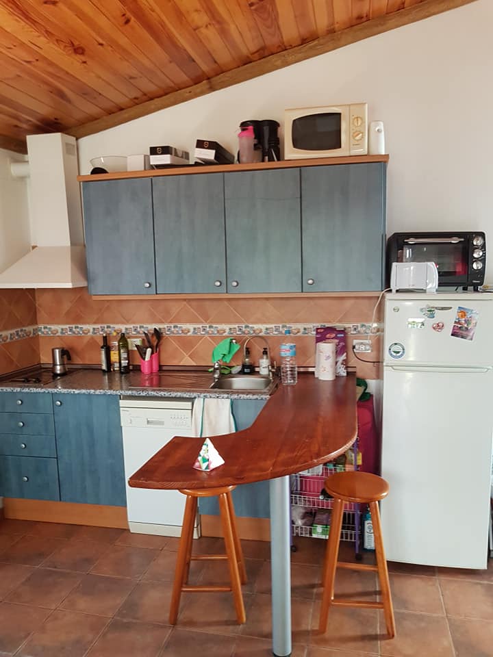 Eine Küche mit blauen Schränken und einem weißen Kühlschrank