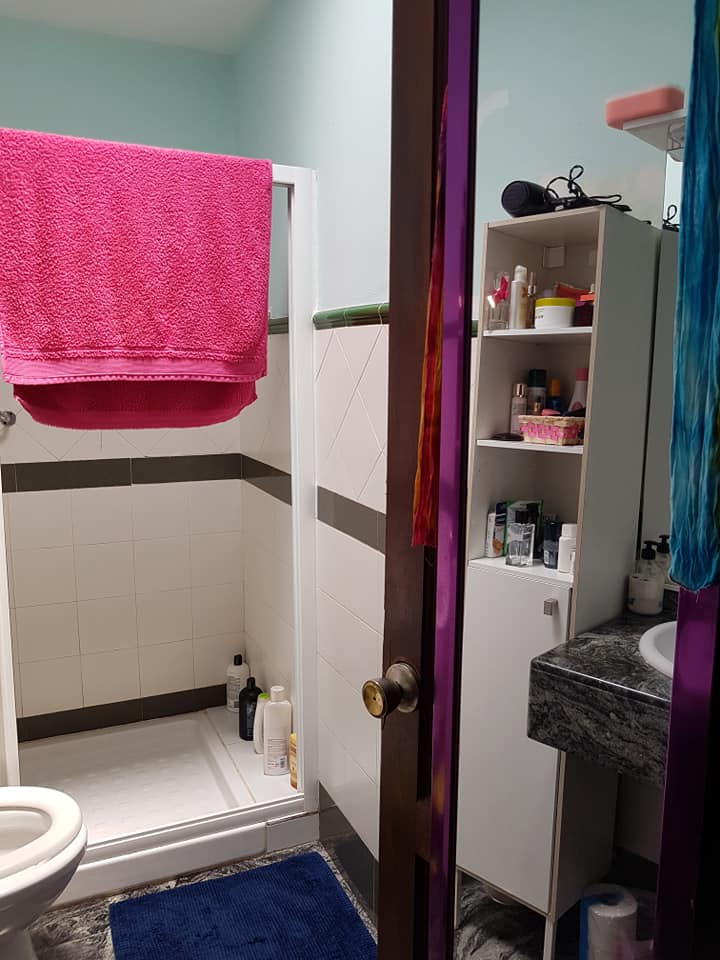 Ein Badezimmer mit einem rosa Handtuch an der Wand