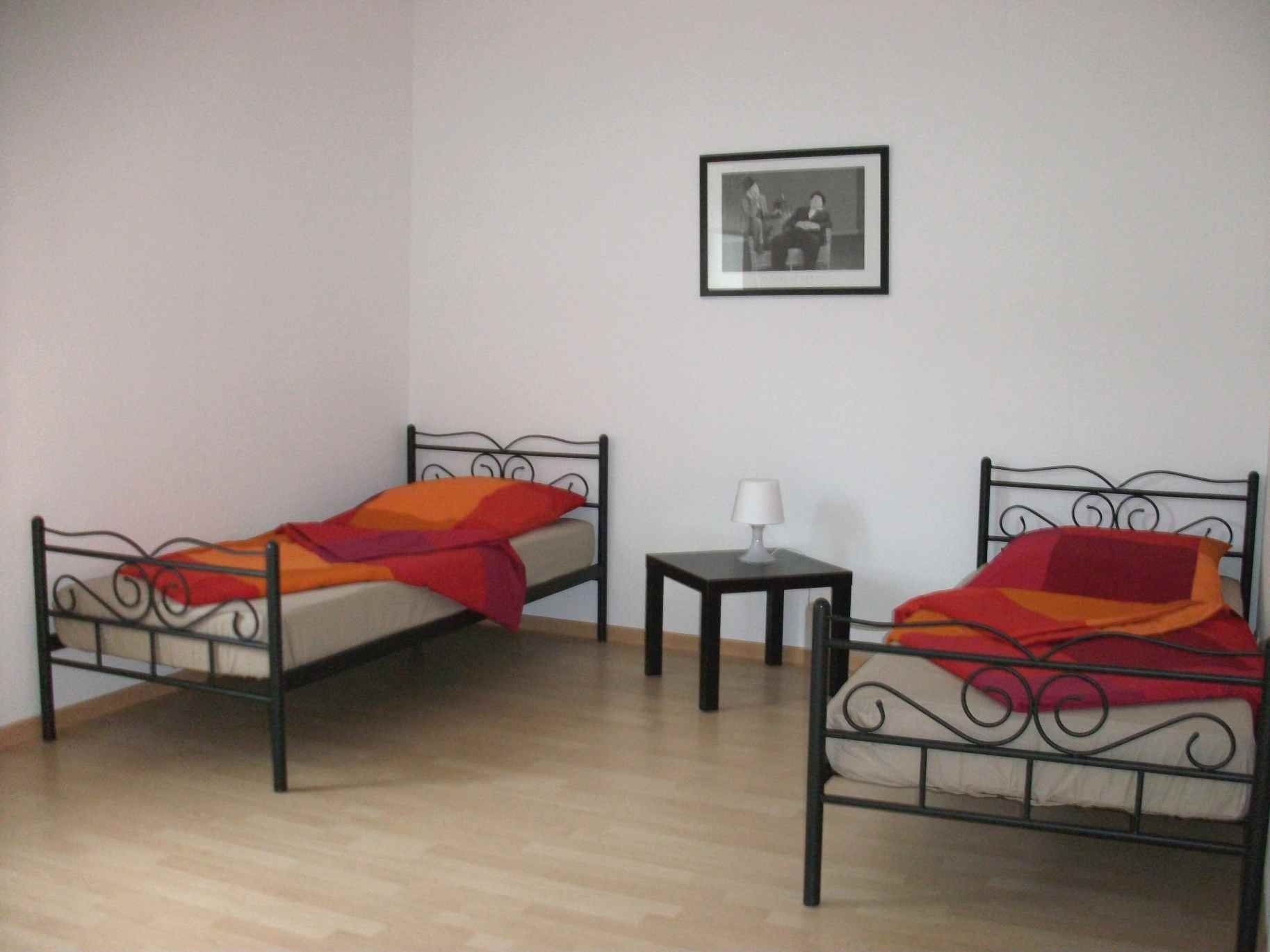 Zwei Betten in einem Zimmer mit einem Bild an der Wand darüber