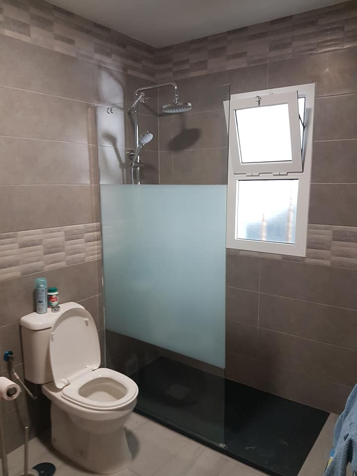 Ein Badezimmer mit Toilette, Dusche und Fenster.