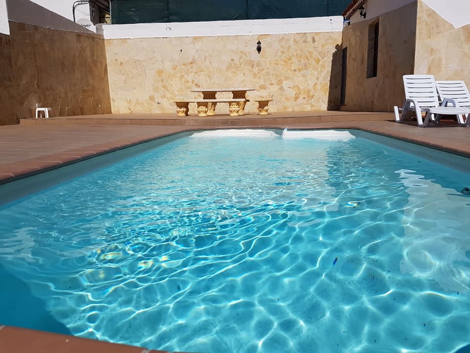 Ein großer Swimmingpool mit Stühlen und einem Picknicktisch im Hintergrund