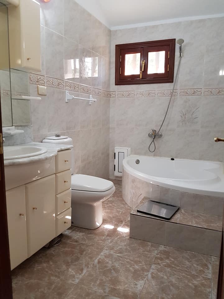Ein Badezimmer mit Badewanne, Toilette, Waschbecken und Spiegel.