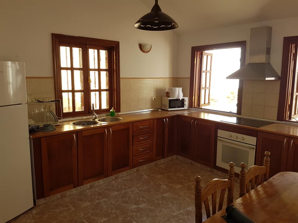 Eine Küche mit Holzschränken und einem weißen Kühlschrank