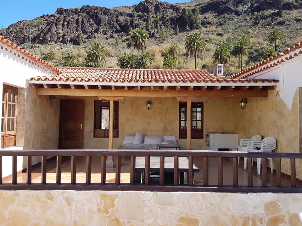 Ein Haus mit Balkon und Bergen im Hintergrund