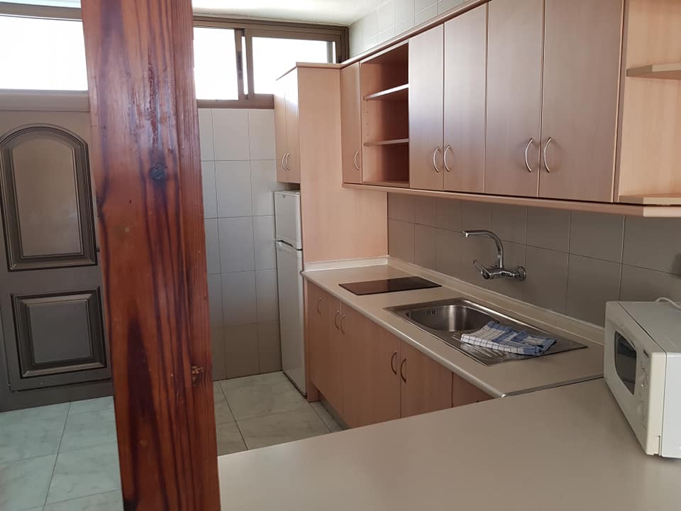 Eine Küche mit Spüle, Mikrowelle und Kühlschrank.