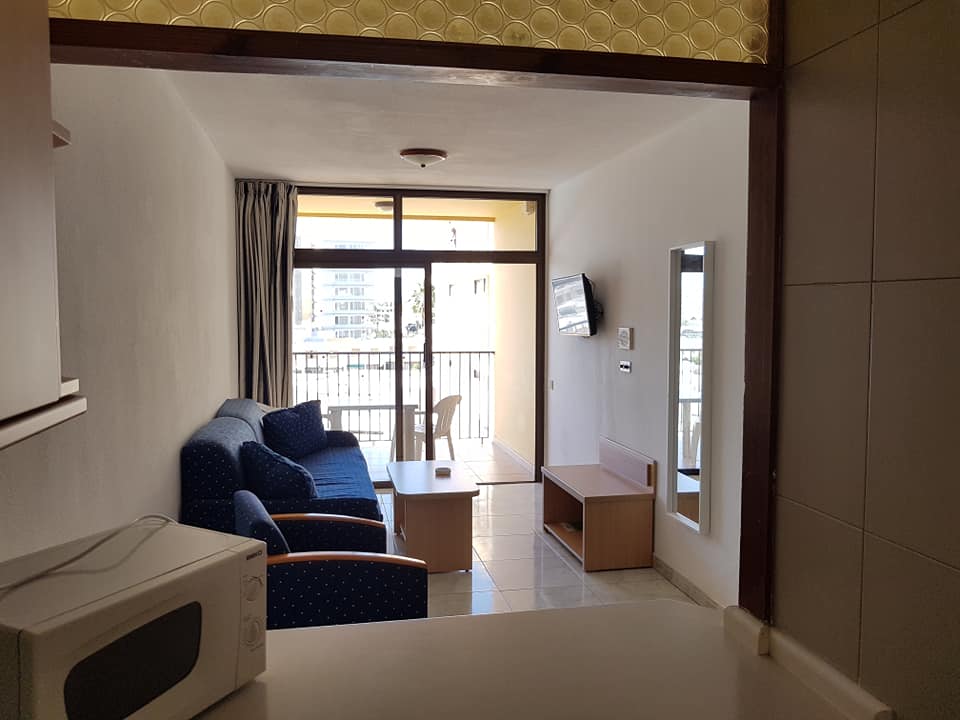 Ein Wohnzimmer mit Couch und Stühlen sowie einer Mikrowelle