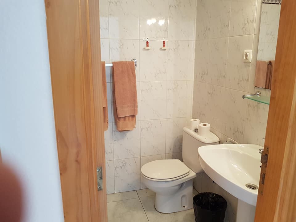 Ein Badezimmer mit Toilette, Waschbecken und Spiegel.