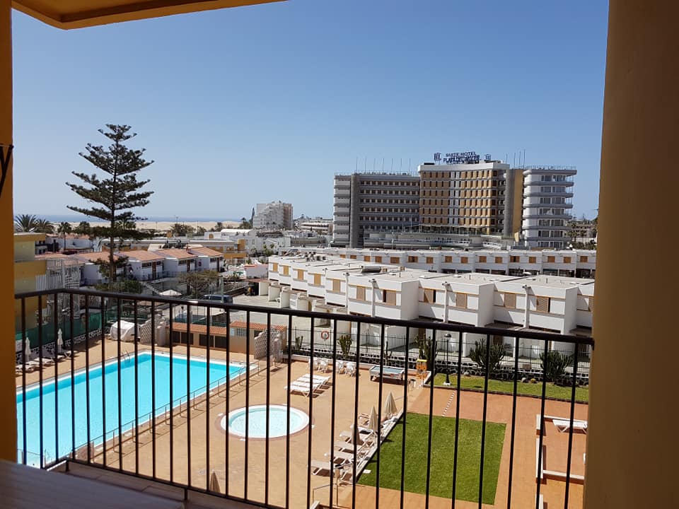Ein Balkon mit Blick auf einen Swimmingpool und Gebäude