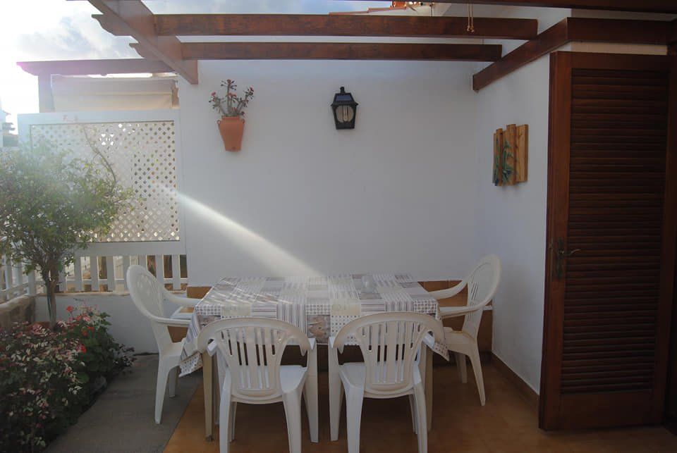 Eine Terrasse mit Tisch und Stühlen unter einer Pergola