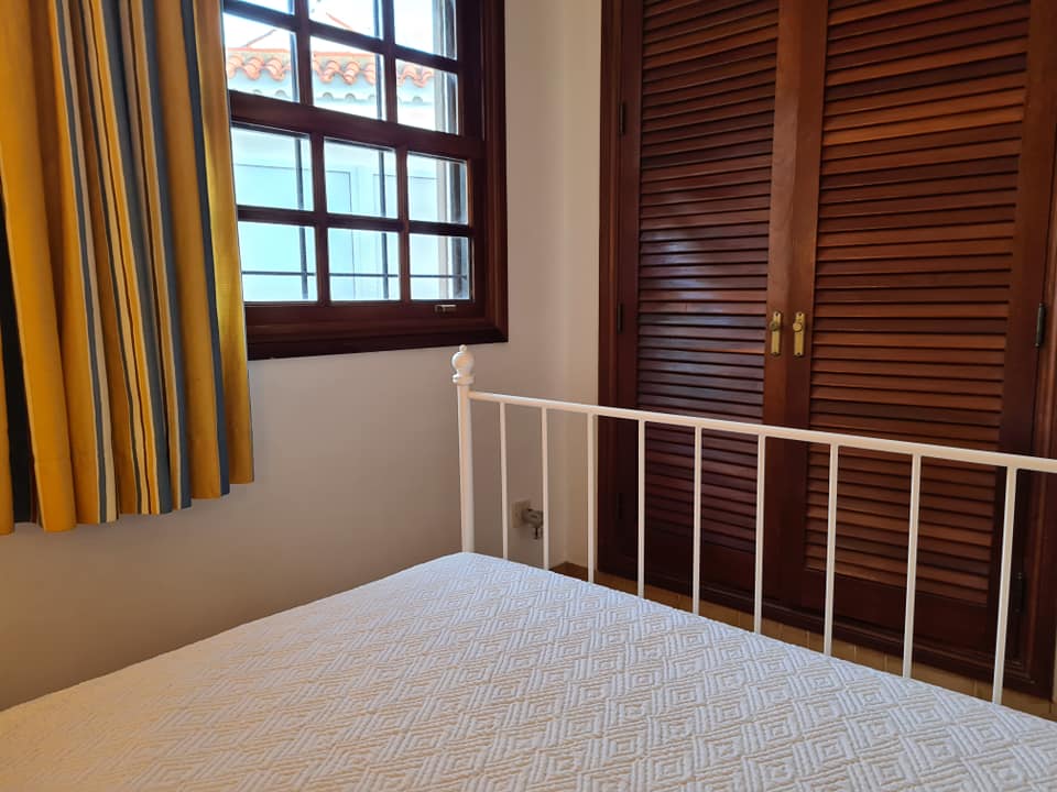 Ein Schlafzimmer mit Bett, Fenster und Schrank.
