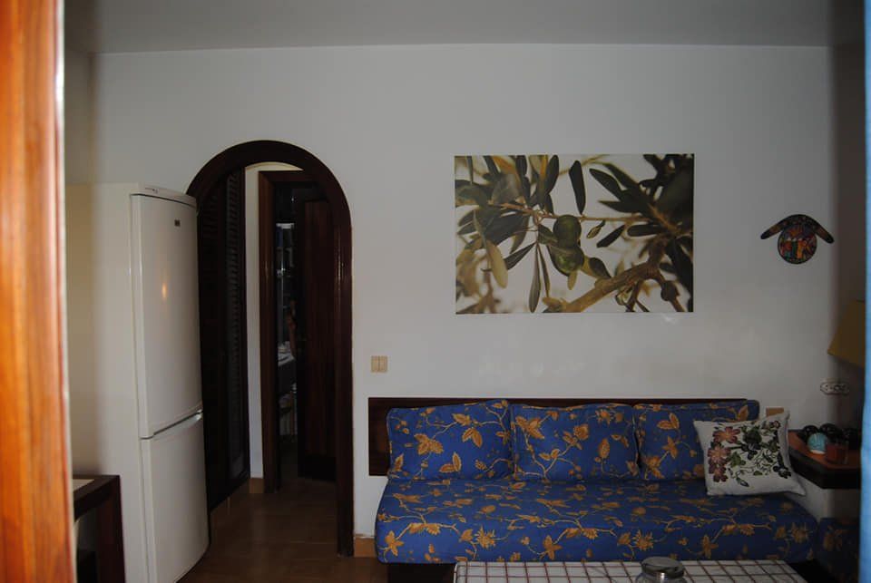 Ein Wohnzimmer mit einer blauen Couch und einem Gemälde an der Wand