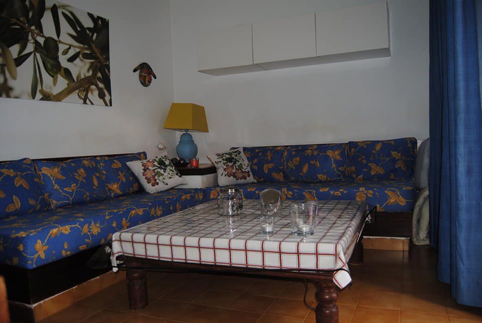 Ein Wohnzimmer mit blauen Sofas und einem Tisch mit karierter Tischdecke.