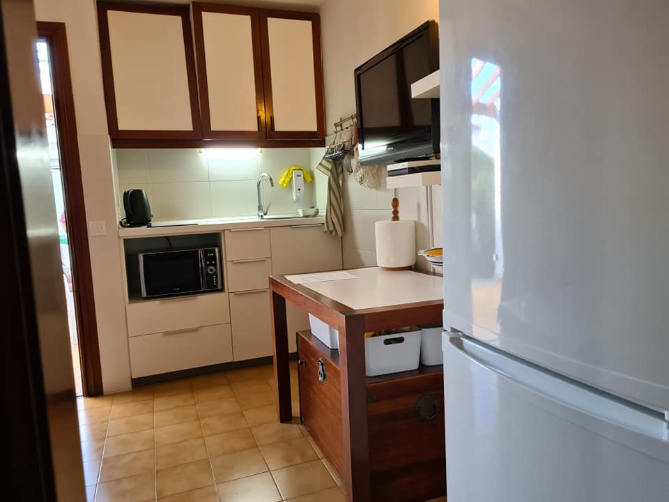 Eine Küche mit einem weißen Kühlschrank und einem Holztisch