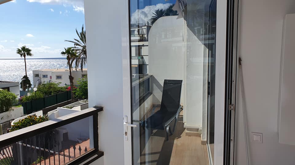 Ein Balkon mit Blick auf das Meer und die Palmen.