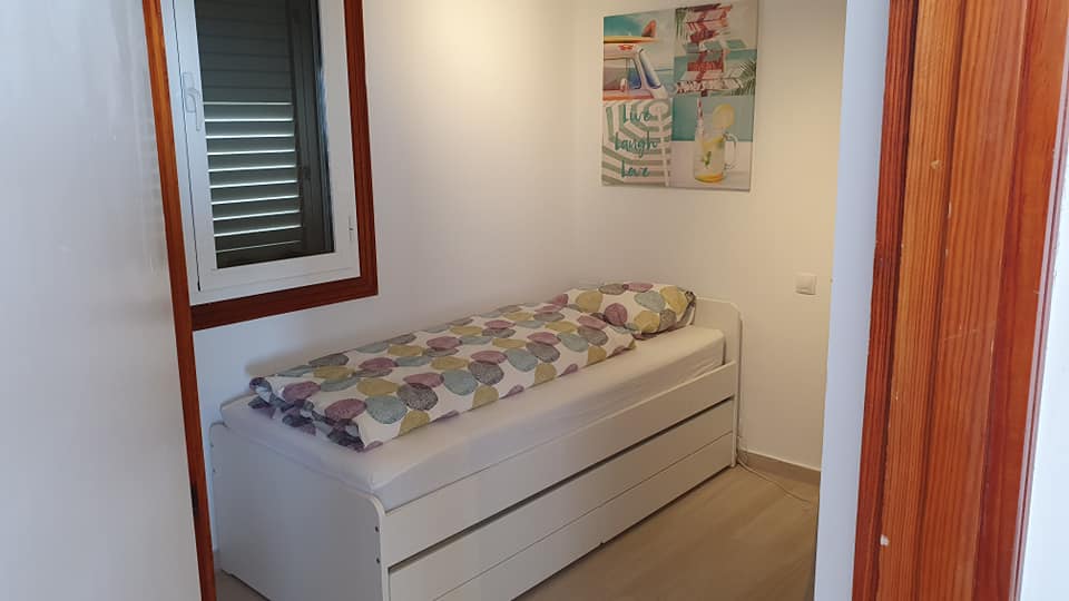 Ein Schlafzimmer mit einem Einzelbett und einem Fenster.