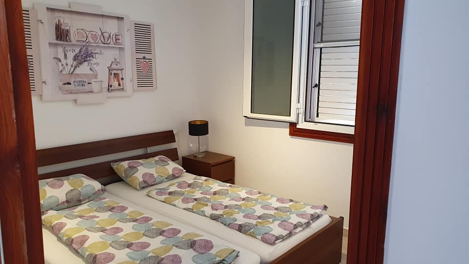 Ein Schlafzimmer mit zwei Betten, einem Nachttisch und einem Fenster.