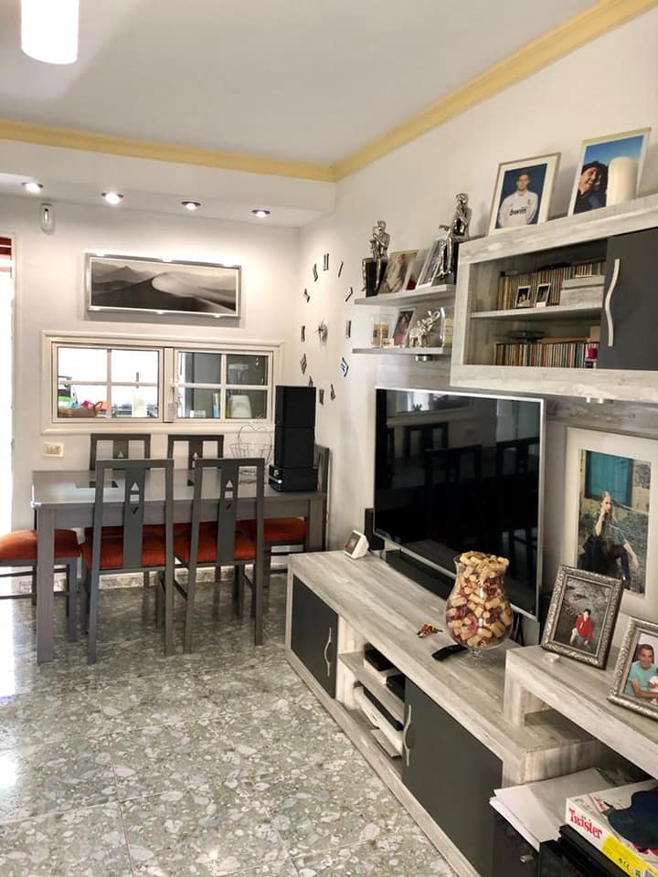 Ein Wohnzimmer mit Tisch und Stühlen und einem Fernseher