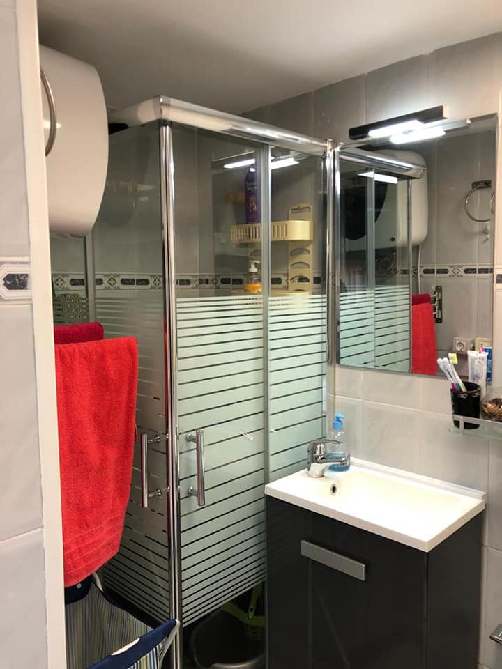 Ein Badezimmer mit Waschbecken, Dusche und Spiegel.