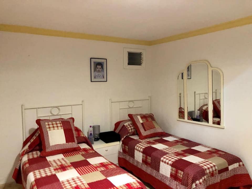 Ein Schlafzimmer mit zwei Einzelbetten und zwei Spiegeln