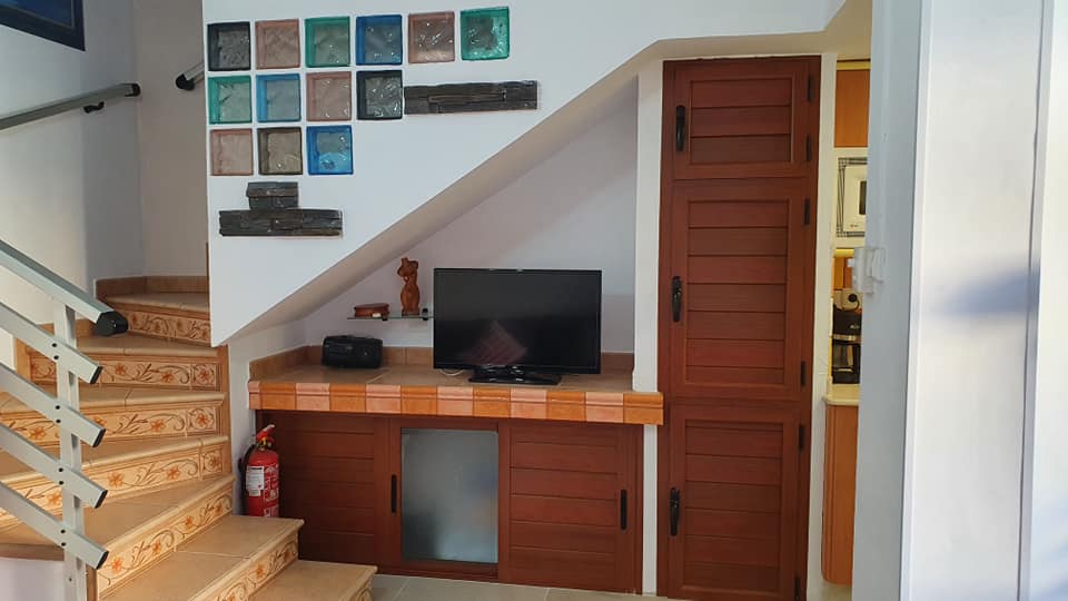Ein Wohnzimmer mit Treppe und einem Flachbildfernseher