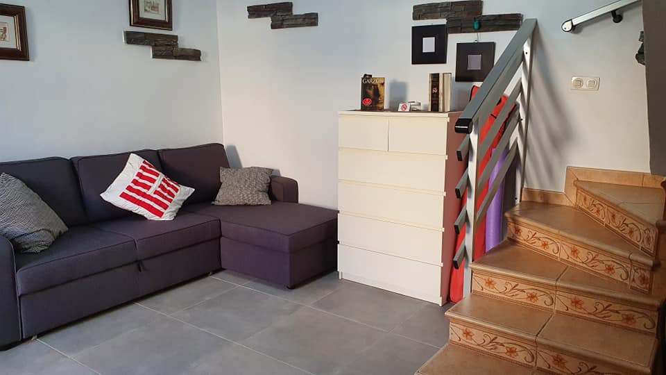 Ein Wohnzimmer mit einer Couch und einer Treppe, die in den zweiten Stock führt