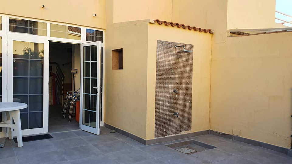 Im Hinterhof eines Hauses gibt es eine Dusche.