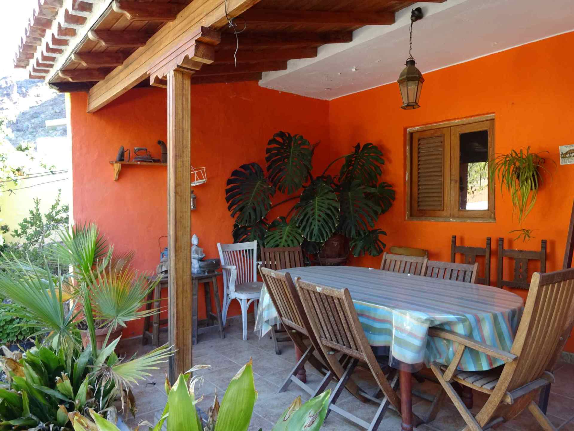 Ein Tisch und Stühle auf einer Veranda mit orangefarbenen Wänden