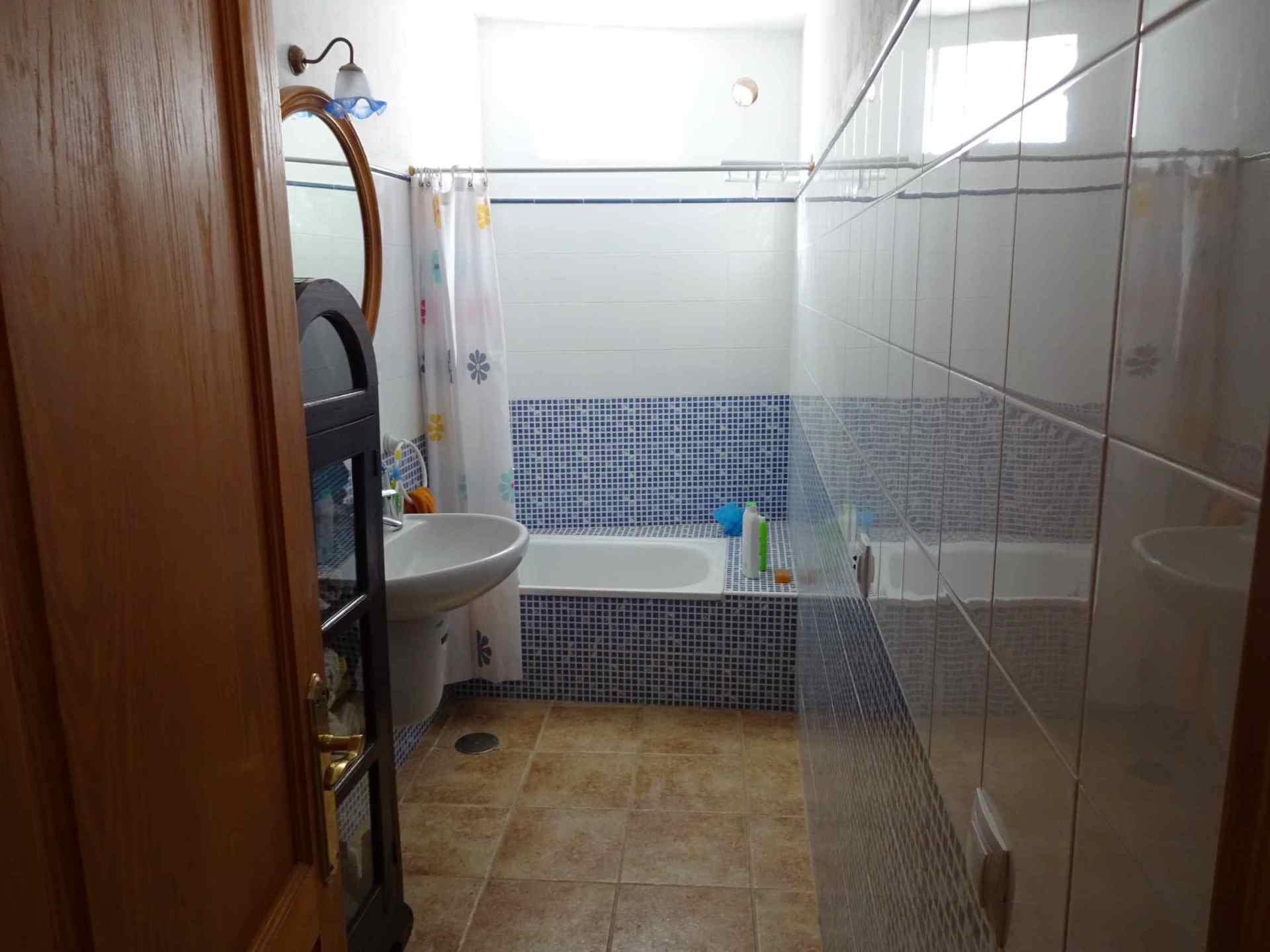 Ein Badezimmer mit Waschbecken, Badewanne und Spiegel.